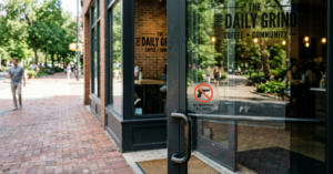 Entrance to The Daily Grind coffee shop with a No Weapons Allowed sign on the glass door