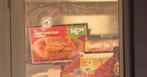 Cracked glass from bullet with advertisements visible